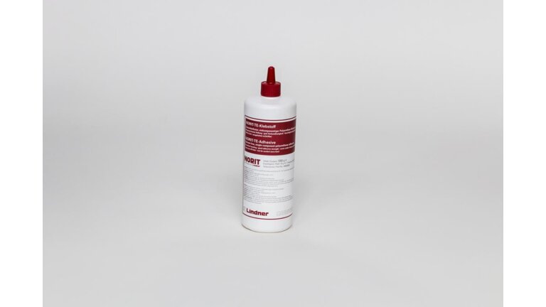 weiße Flasche des NORIT-Klebstoffes mit rotem Etikett und rotem Verschluss.